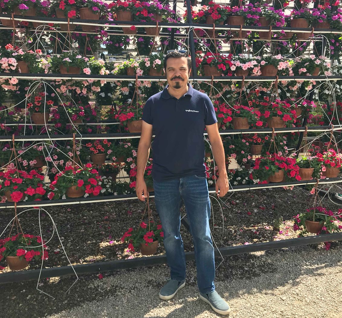 Can Erol posing in front of flowers hanging baskets Turkey